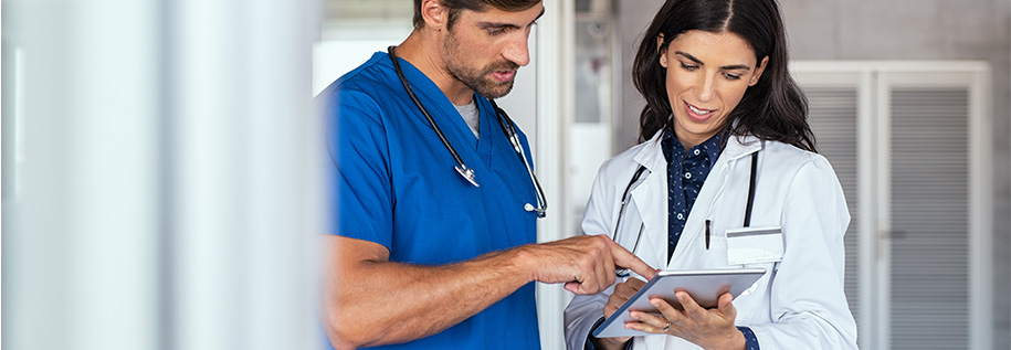 Two doctors look at a computer tablet